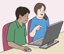 Zwei Personen sitzen vor einem Computer